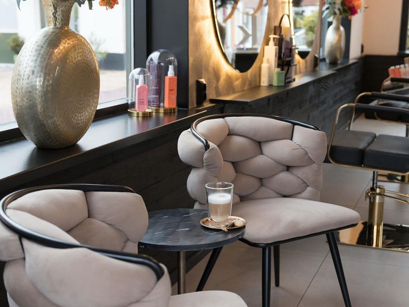 De salon in Rockanje: bouclé stoelen en ronde gouden spiegels
